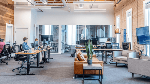 A open floor plan office with people scattered throughout working at their computers. 