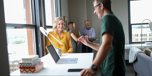 A group of people having a discussion in a brightly lit office.