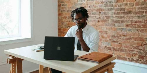 Businessman working hard at his desk, looking at this computer.