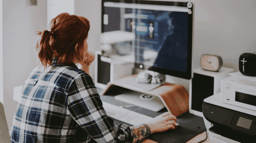 A woman works at her computer in her home office