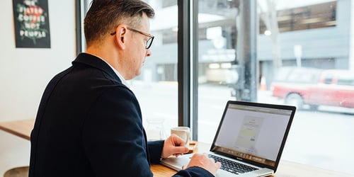 A businessman working on his computer at a coffee shop.