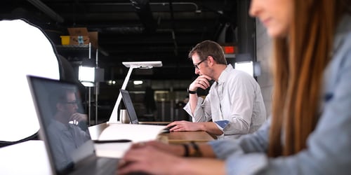 Man working on a computer in an office desk.