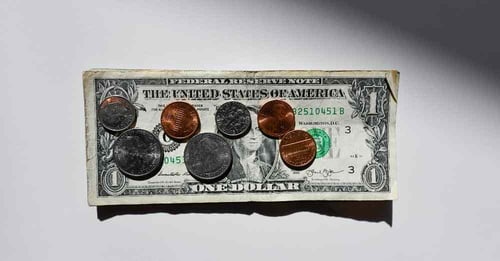 A small pile of American currency sits on a table.