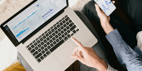 Two people sit beside one another looking at financial reports.