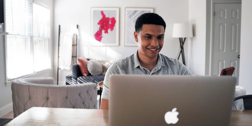 A person sits on their computer taking a video call.