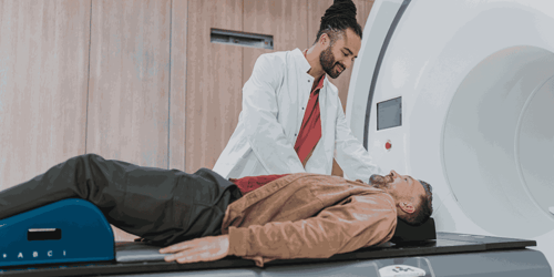 A medical professional cares for a patient lying on an MRI machine table. 