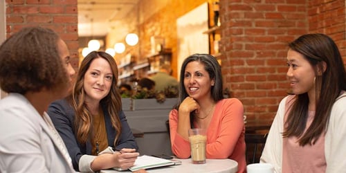 Four employees sitting engaged at an office meeting.