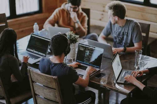 Group of a people work on their laptops independently in a communal office space