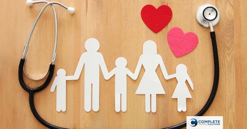 A stethoscope surrounds a paper cutout of a family