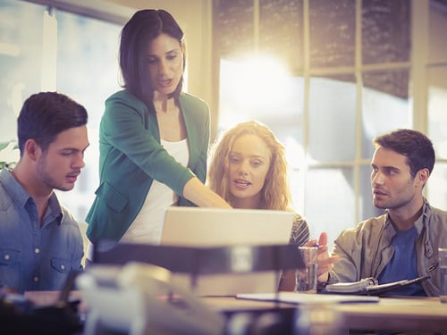 A group of people sit around a conference table having a serious discussion