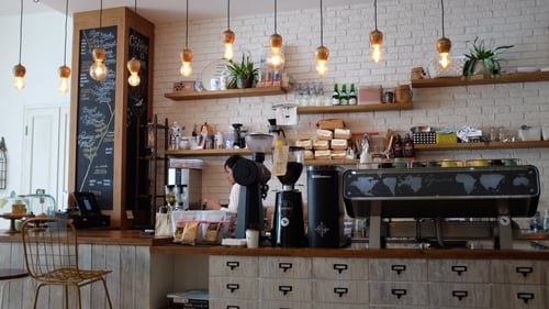 A person works behind the counter in an empty coffee shop