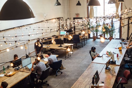 People work at their desks in a modern style industrial office space