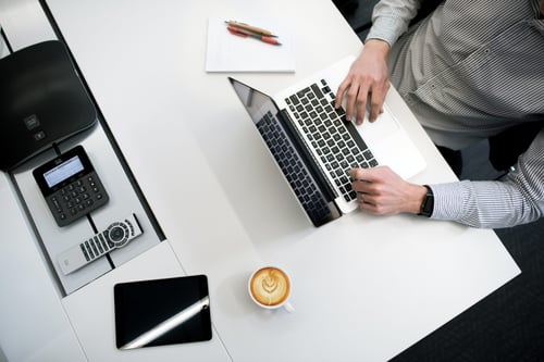 A person sits at their computer typing