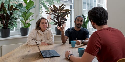 A group of colleagues sitting at a table having a discussion.