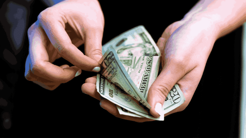 Someone counts money, only there hands are in view.