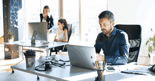 Man at his desk working on his computer.