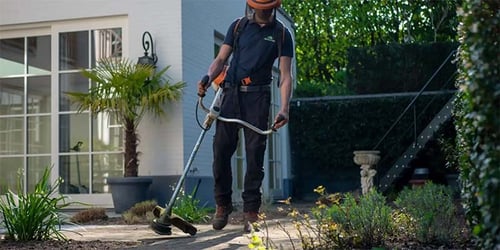 A household employee works to maintain the lawn and garden.