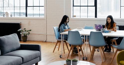 Two employees hard at work in their office work room