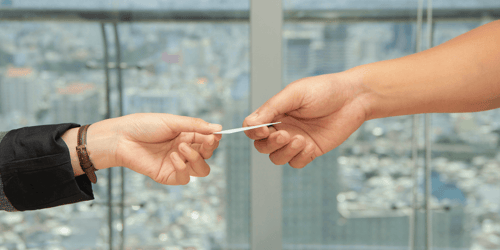 Two people holding the same debit card.