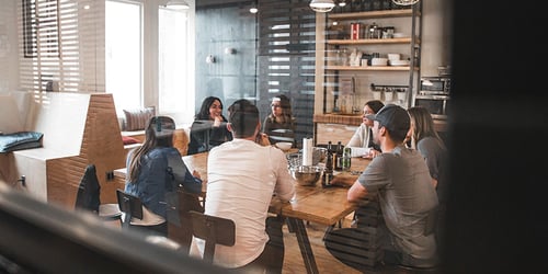 A group of people sit having a discussion at conference restaurant table