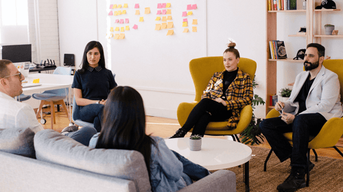 A group of people sit in a relaxed work environment having a conversation