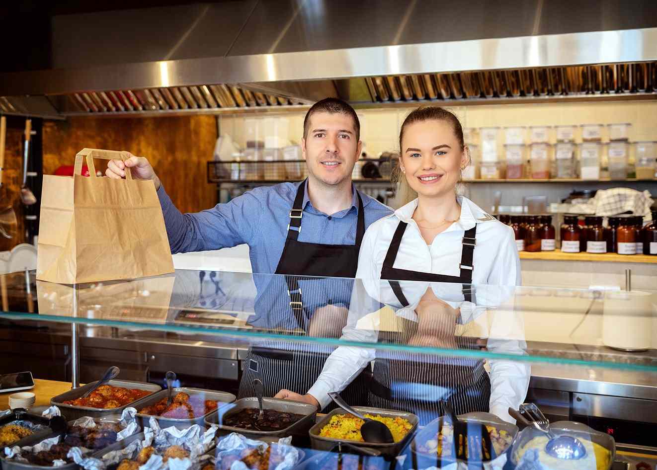 Franchise employees holding a takeout order