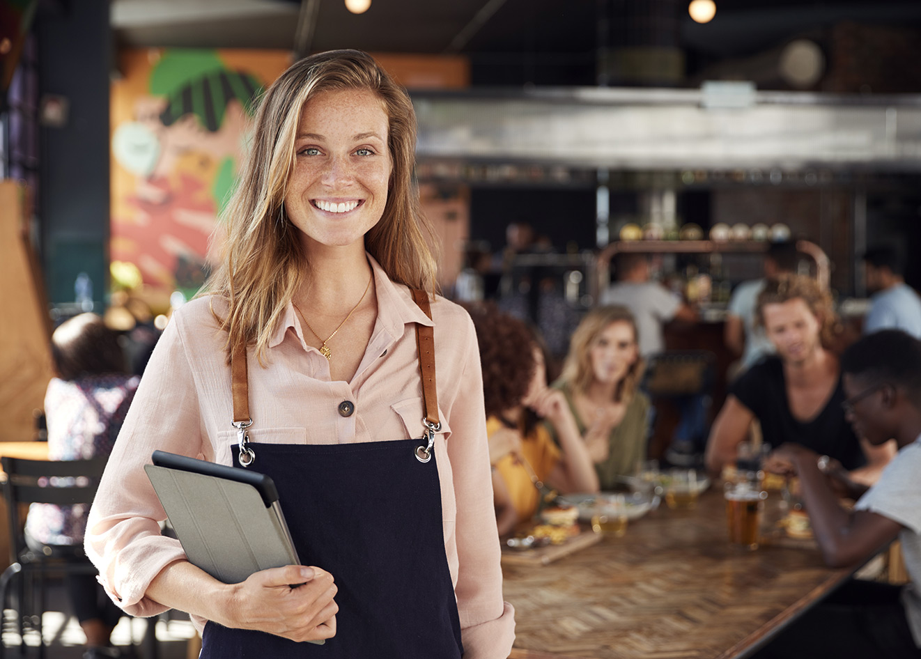 Server holding a tablet in a trendy restaurant