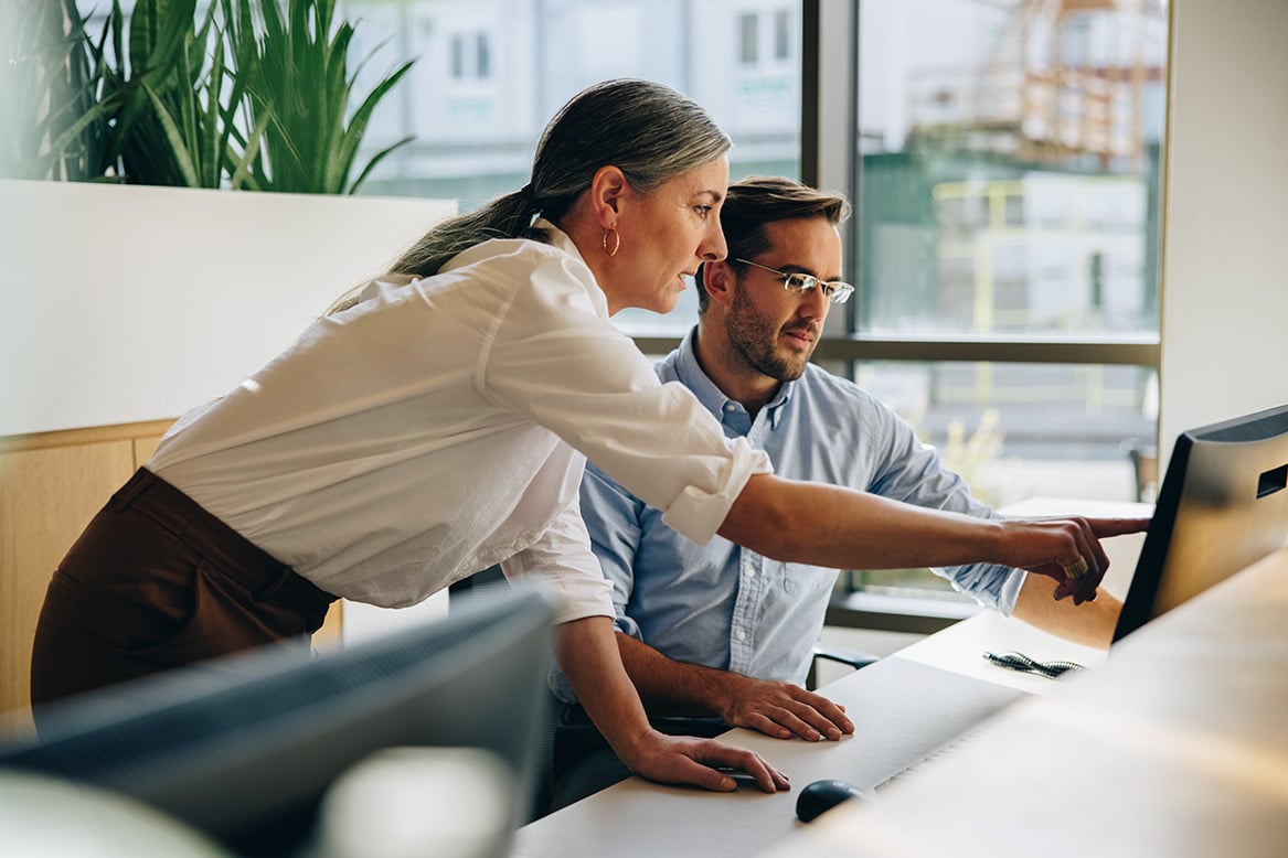 Coworkers reviewing work process on computer