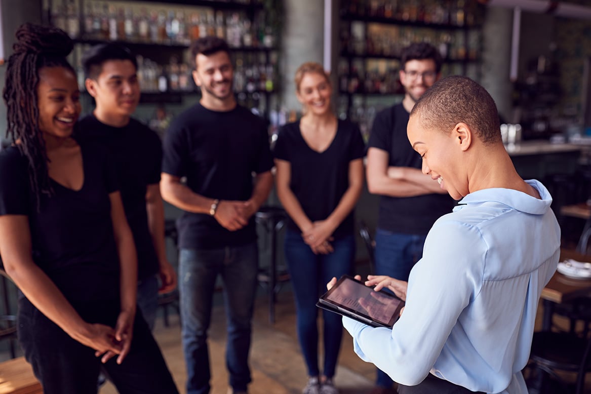 Restaurant manager reviewing menu with staff