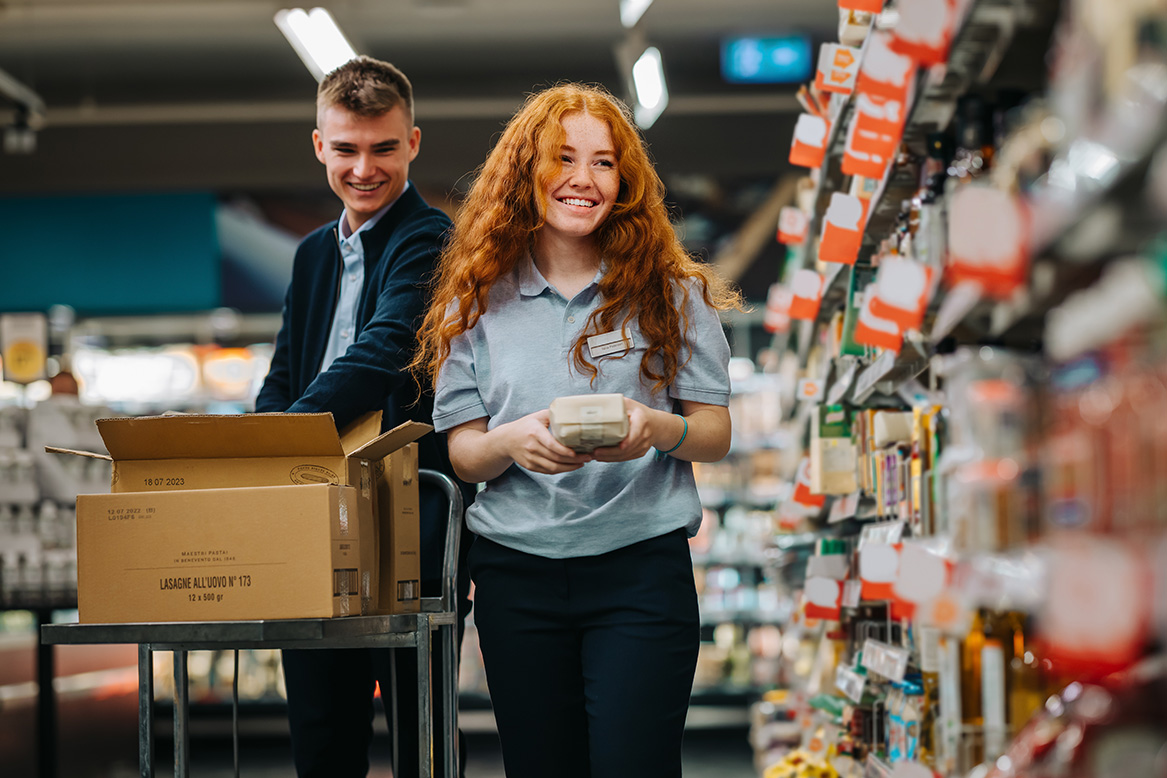 Employees re-stocking the supermarket shelves