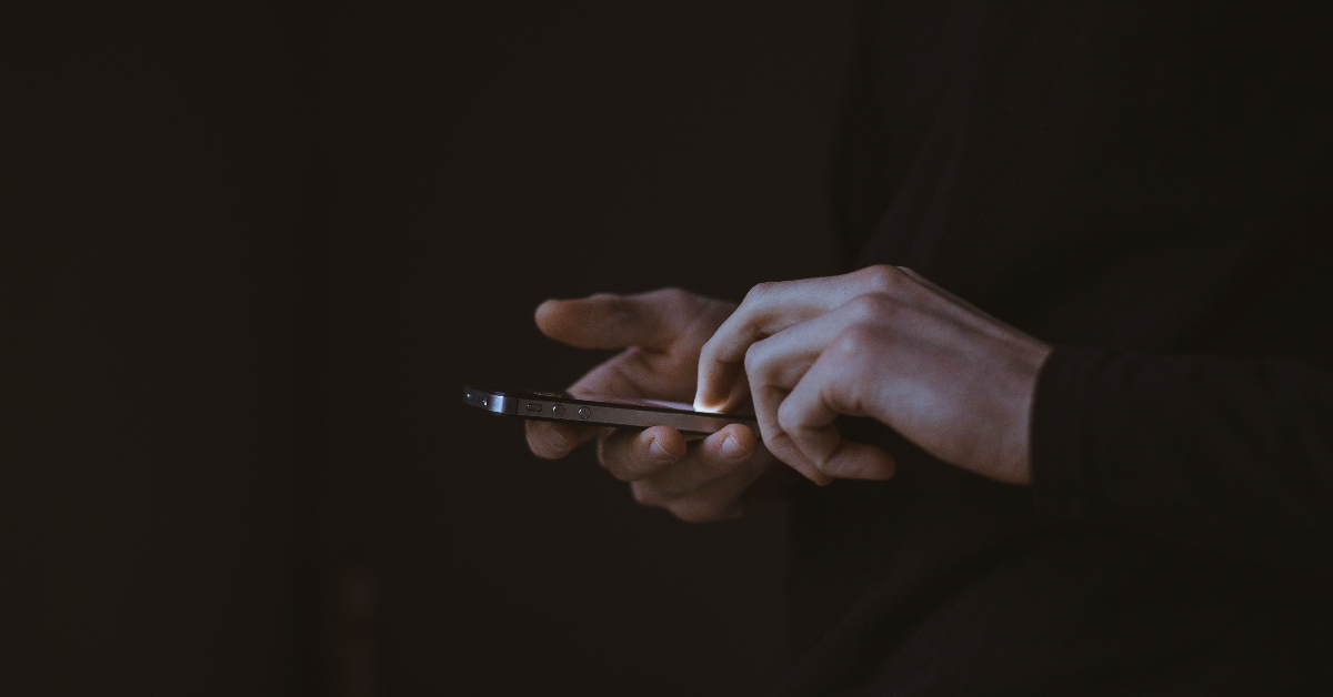 A person holding their phone with only their hands in view.