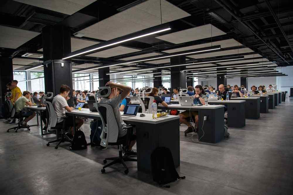 A group of people work in an open floor plan style office