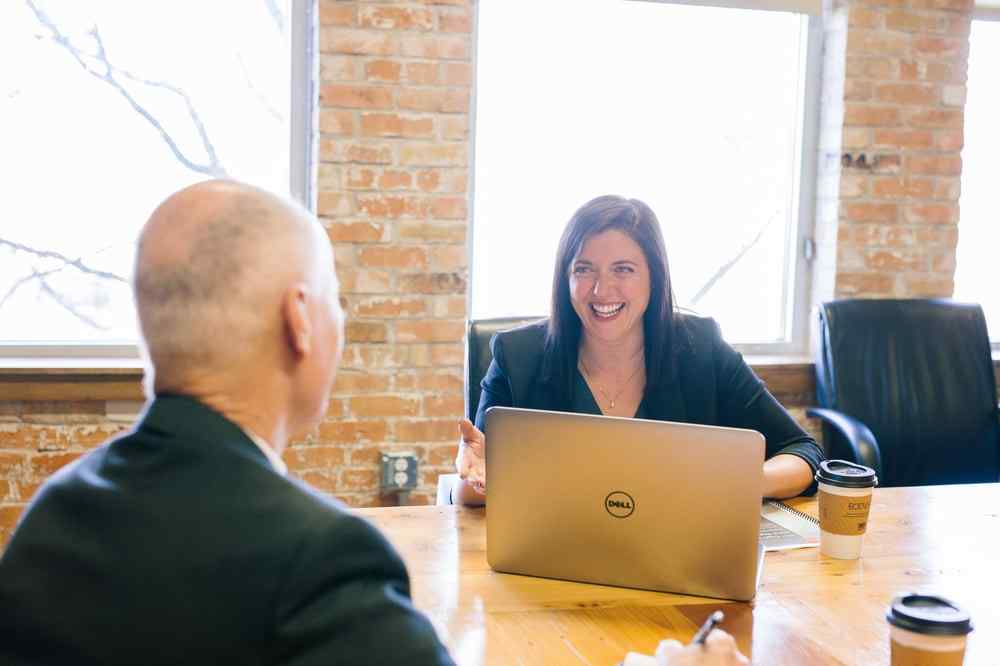 Two people have a discussion at a conference room table