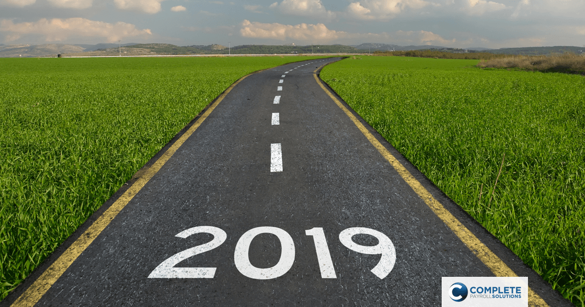 An empty road surrounded by grass with the year 2019 spelled out