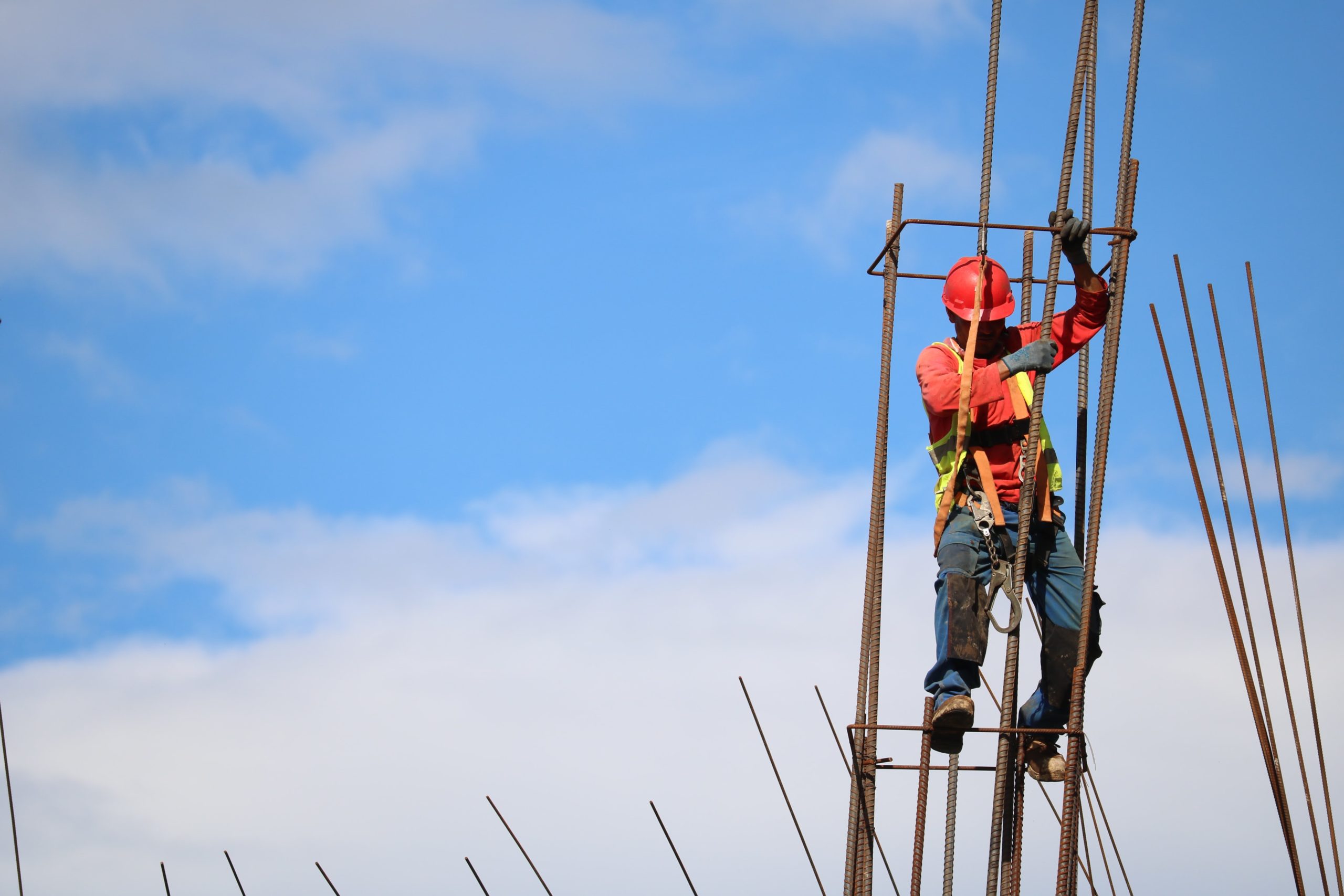 A construction worker climbs a ladder