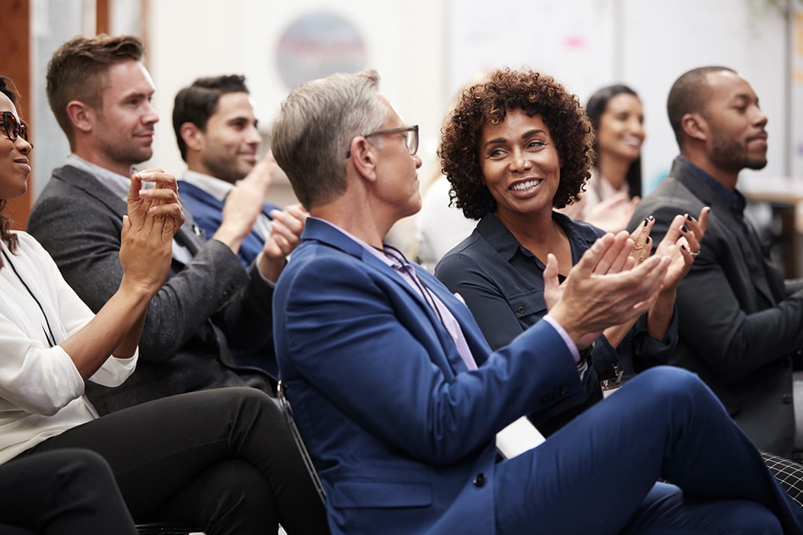 Corporate employees applauding an announcement